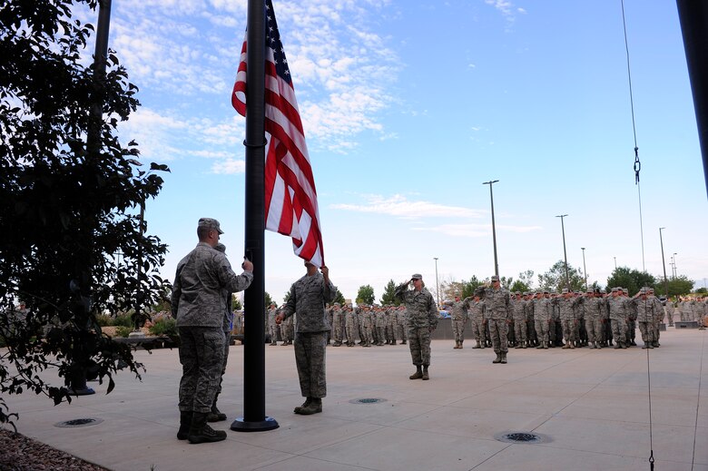 Airmen with 50th Space Wing show their respect to the Stars and Stripes during reveille Aug. 7, 2014, at Schriever Air Force Base, Colo. The wing holds either reveille or retreat every month. (U.S. Air Force photo/Christopher DeWitt)