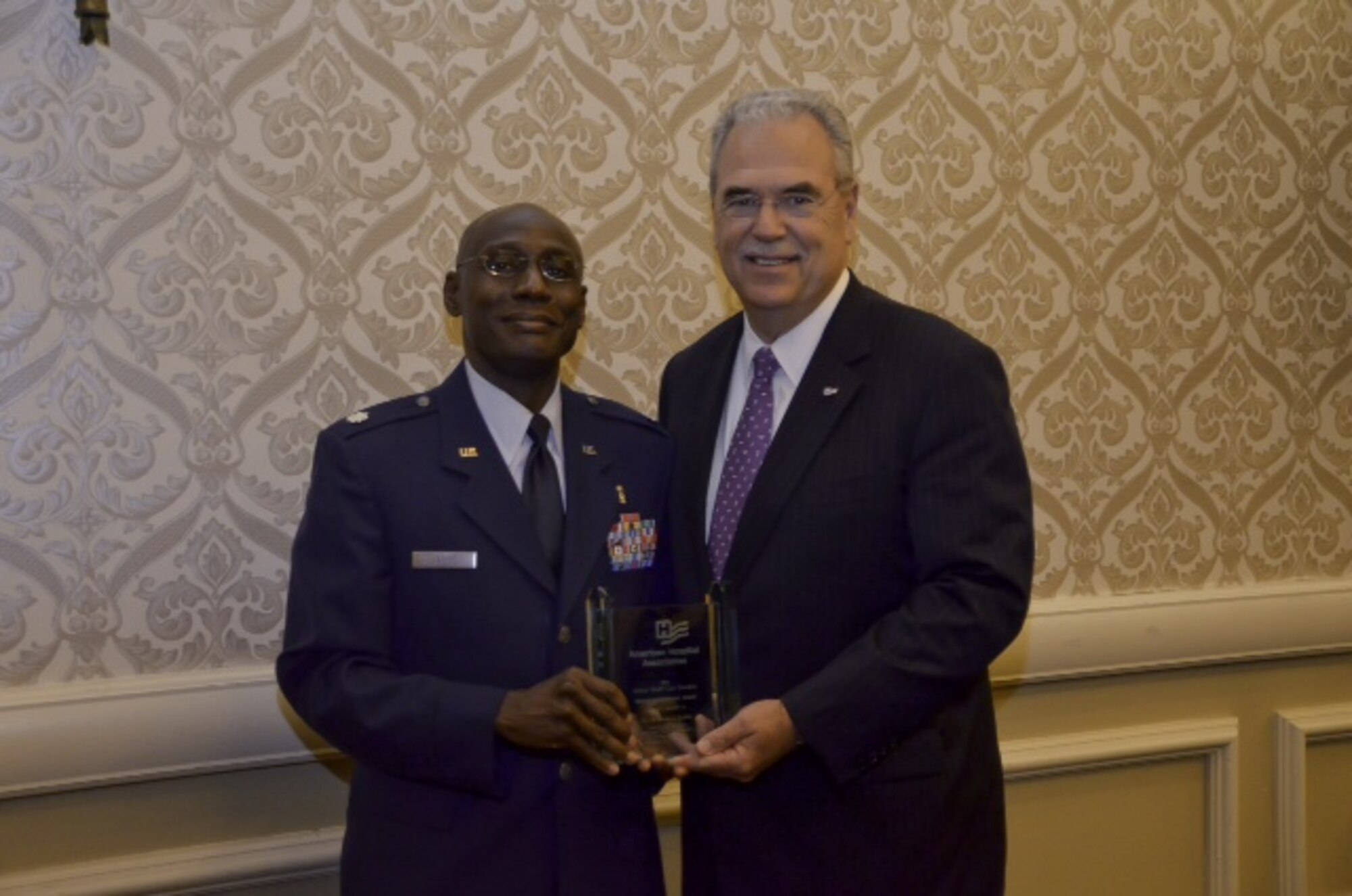 Lt. Col. Derek Larbie, flight commander of the 377th Medical Group's pharmacy, is presented the American Hospital Association’s 2013 Federal Health Care Executive Special Achievement Award by Richard Umbdenstock, AHA's president and chief executive officer. (Courtesy photo)