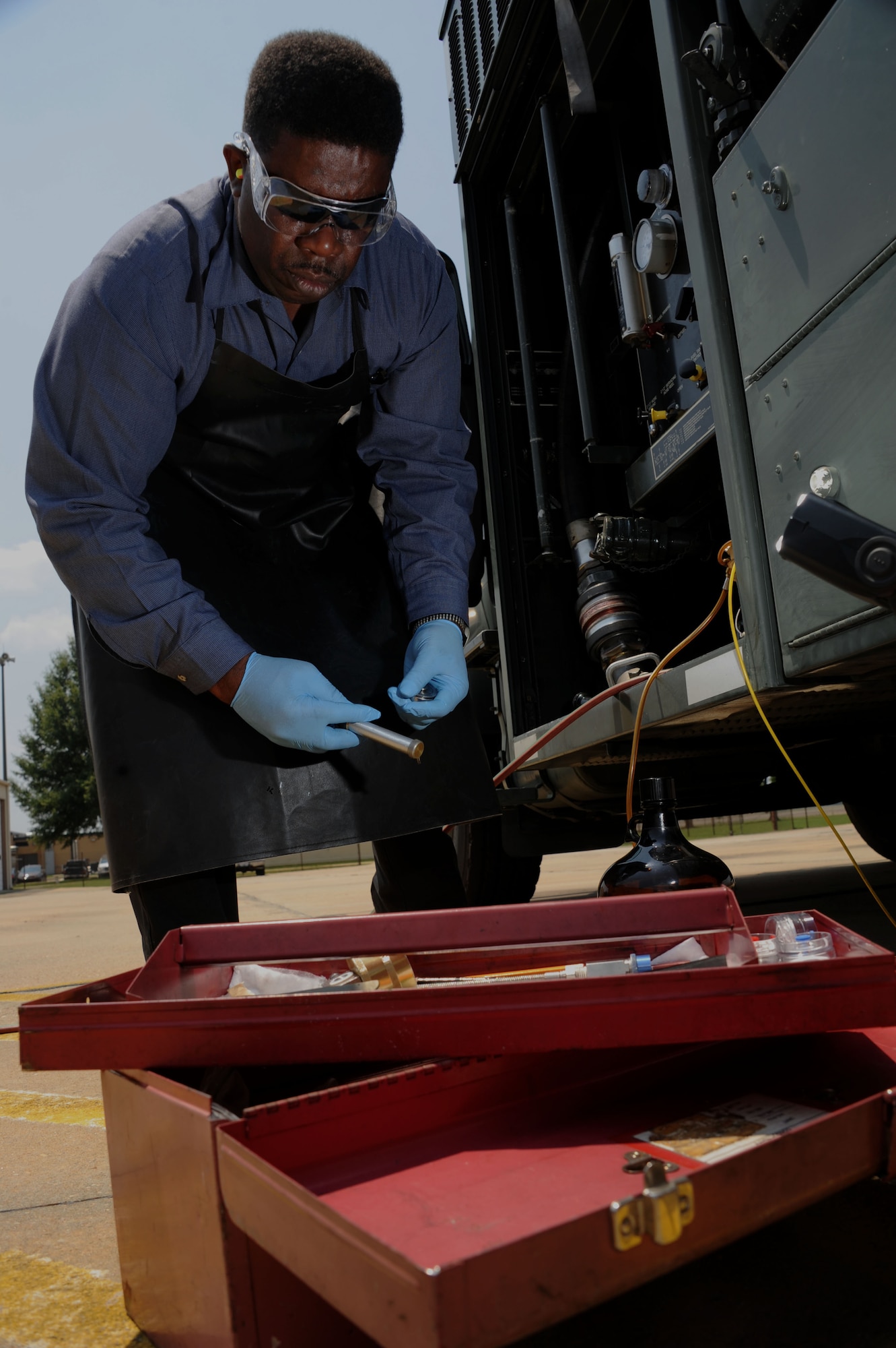 John Brown, a fuels lab supervisor and assistant manager from the 42nd Logistics and Readiness Squadron Fuels, extracts fuel from a tank truck at Maxwell Air Force Base Ala., Aug. 6, 2014. Brown was testing for excessive amounts of water and sediments in the fuel. (U.S Air Force photo/Airman 1st Class Alexa N. Culbert)