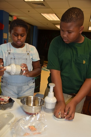 Micah Coward and Laila Winfield chop mushrooms as they prepare pizzas Aug. 13, 2014, at the Joint Base Charleston – Weapons Station Youth Center. Children participating in the Fleet and Family Support Center’s summer youth program were treated to three “Cooking on a Budget, International Style” classes which focused on creating menu plans, shopping and price comparisons, and best of all, preparing, cooking and eating their creations. Besides pizza, the children also prepared tacos and fried rice. (U.S. Air Force photo/Eric Sesit)