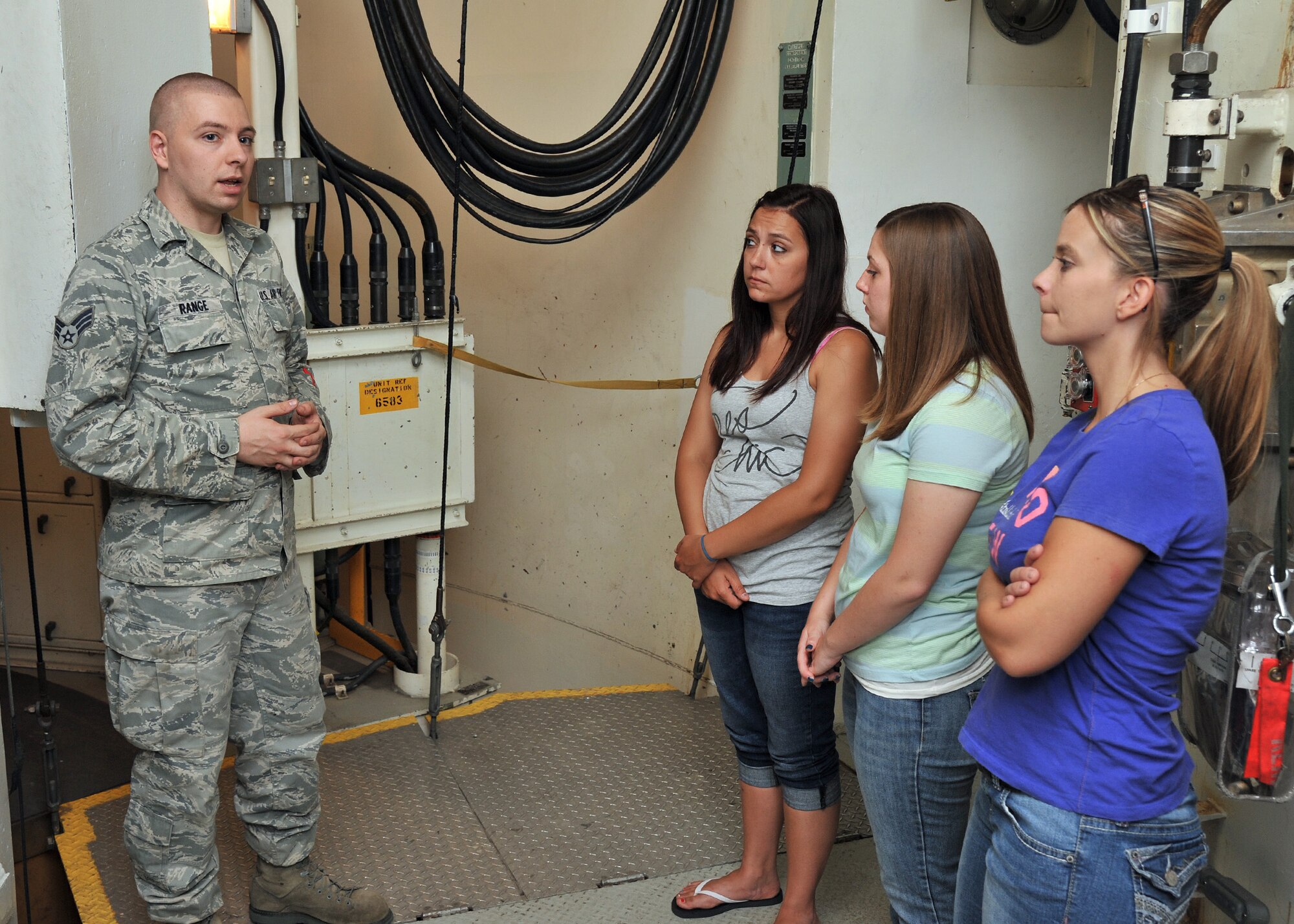 Senior Airman Daniel Range, 341st Maintenance Operations Squadron trainer maintainer, briefs key spouses Aug. 2 during a tour of the T-9 launch facility maintenance trainer at Malmstrom Air Force Base, Mont. A similar tour is given each month to Airmen who have just arrived to the installation and promotes understanding of the 341st Missile Wing’s mission. (Air Force photo/John Turner)