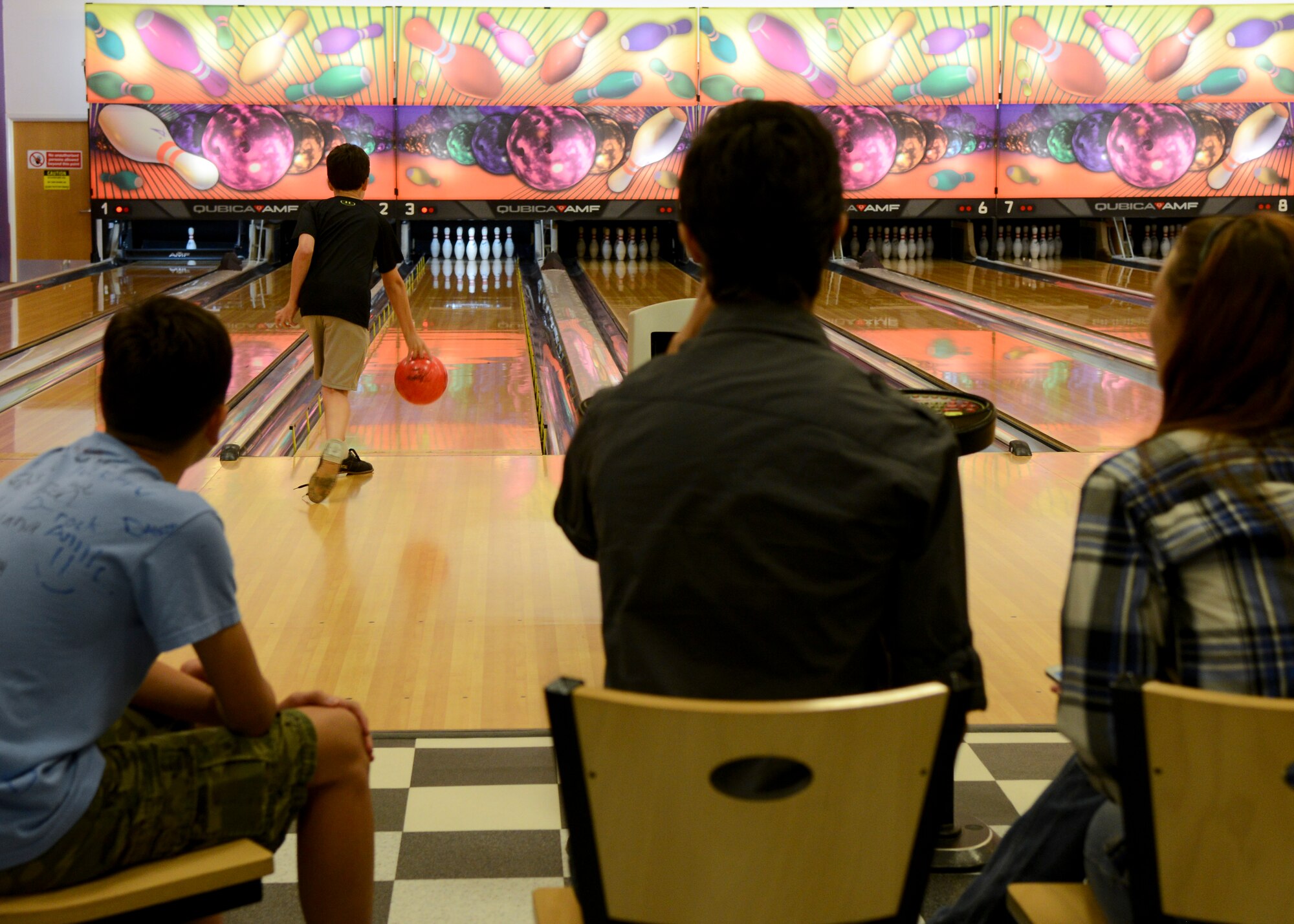 Families of deployed Airmen play a game of bowling during a Hearts Apart event for families of deployed Airmen hosted by the 100th Maintenance Group Aug. 12, 2014, at the bowling alley on RAF Mildenhall, England. The event featured a craft table, bouncy castle, free bowling and a meal provided by the 100th MXG. (U.S. Air Force photo/Airman 1st Class Victoria H. Taylor/Released)