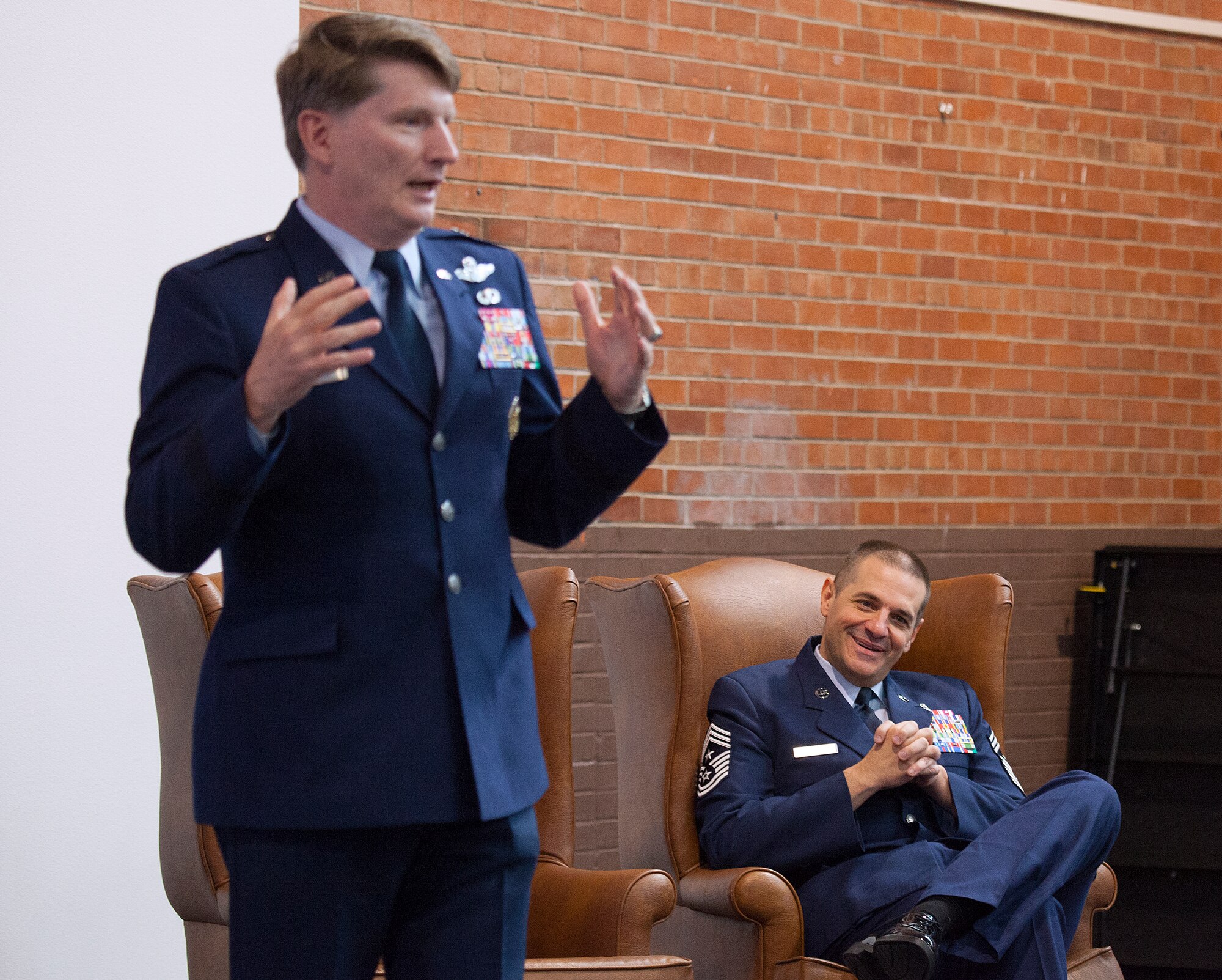 Chief Master Sgt. David Nordel, 20th Air Force and Task Force 214 command chief, smiles as Brig. Gen. Robert Thomas, Jeanne M. Holm Center for Officer Accessions and Citizen Development commander, talks about Nordel’s career during his retirement ceremony August 8, 2014, in Fall Hall on F.E. Warren Air Force Base. Nordel and Thomas served together as wing commander and wing chief at Fairchild AFB, Wash. (U.S. Air Force photo by R.J. Oriez)