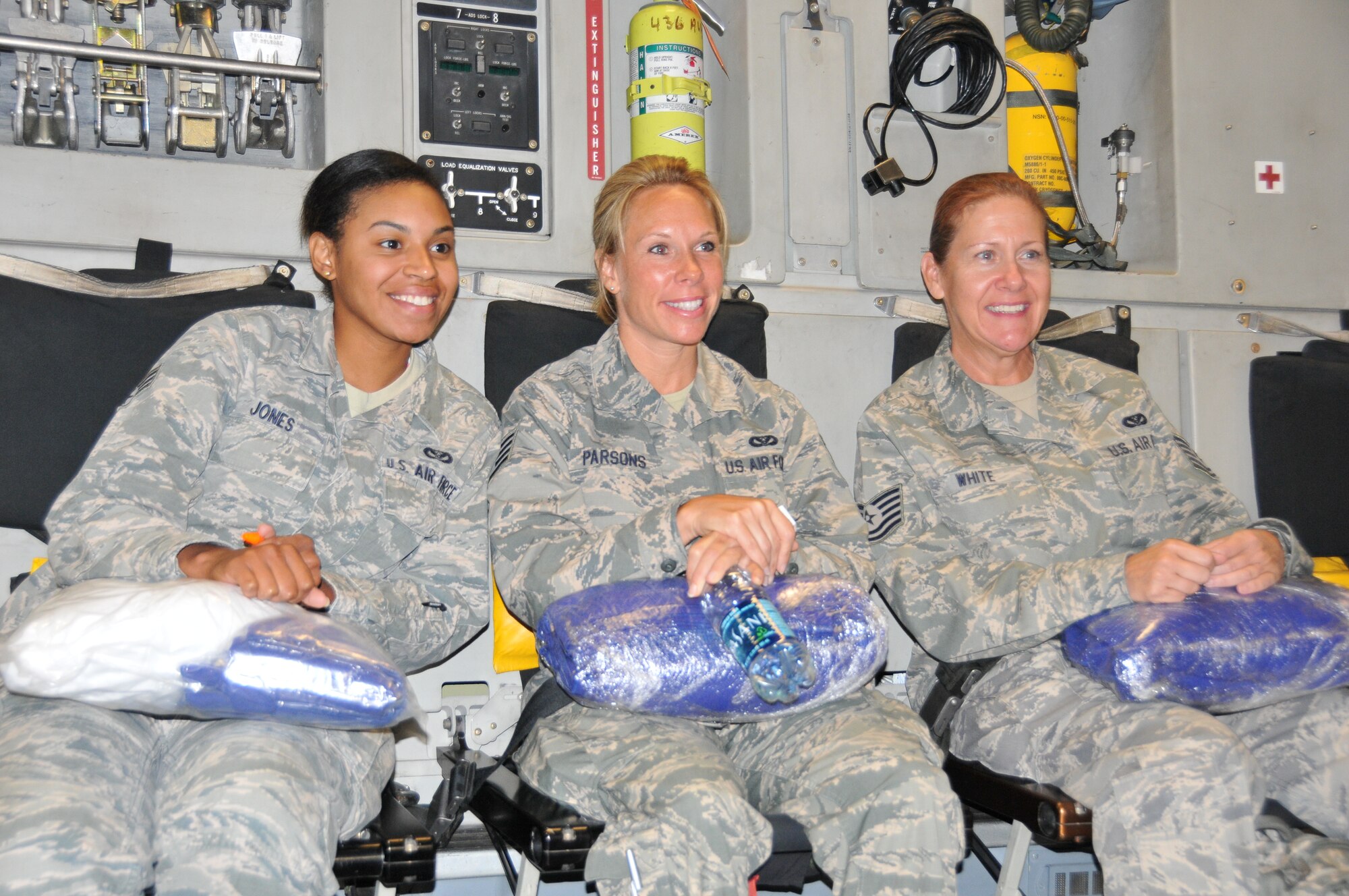 From left to right, Senior Airman Jasmine Jones, Staff Sgt. Story Parsons, Technical Sgt. Oline White, 512th Civil Engineer Squadron members, take a moment to capture a memory during their flight to New Mexico for their two-week annual training assignment July 19, 2014. Twenty-six reservists participated in Operation Footprint, building homes for a Navajo reservation in Gallup, N.M. Operation Footprint is collaborative effort coordinated through the Department of Defense's Innovative Readiness Training program, which provides real-world training opportunities for reservists. (U.S. Air Force photo/Staff Sgt. Mercedes Crossland)