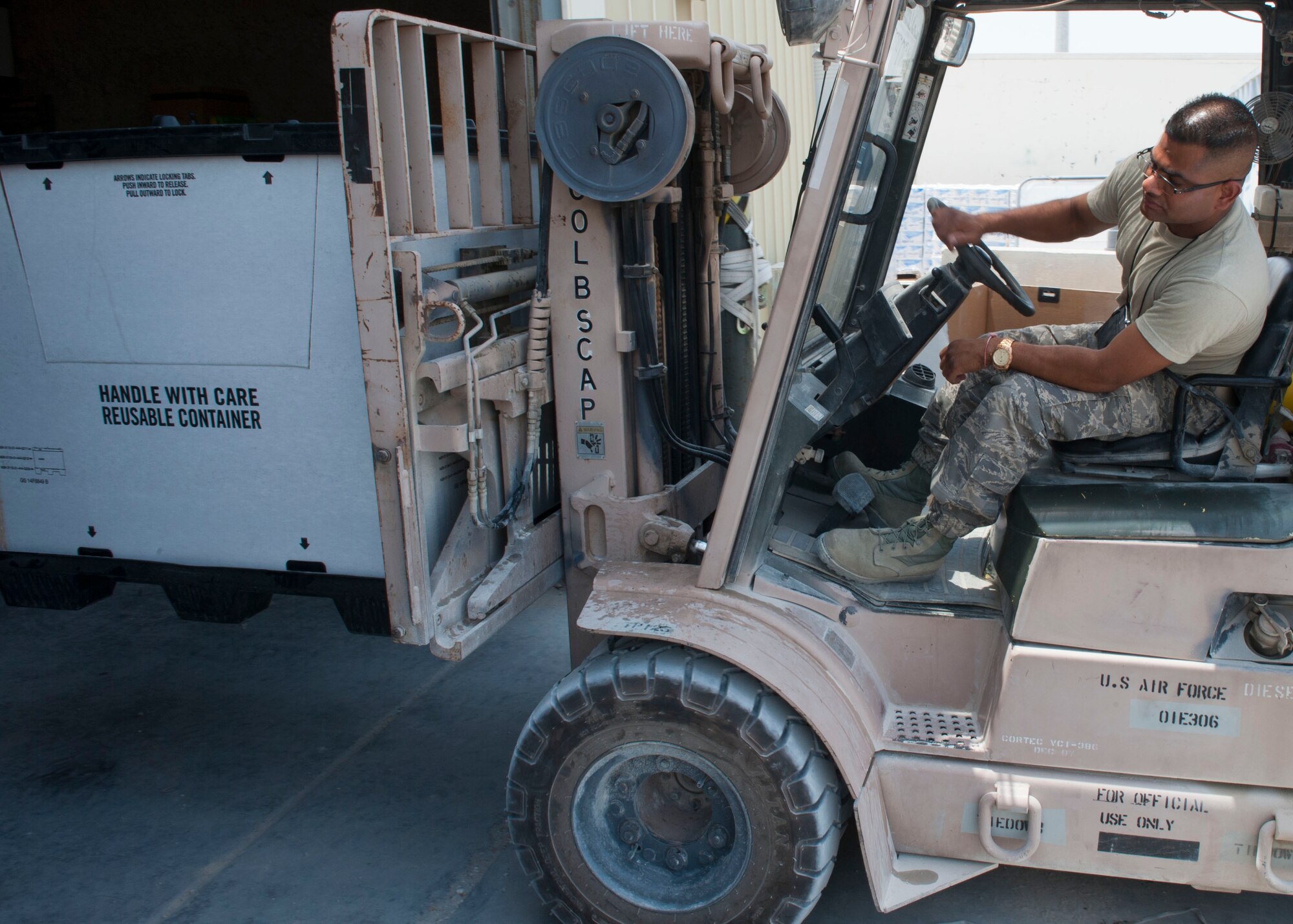 U.S. Air Force Tech. Sgt. Gautambhai Patel operates a forklift to help ready humanitarian aid pallets at a location in Southwest Asia Aug., 11, 2014. The pallets consist of food and water for humanitarian aid drops to assist displaced citizens in the vicinity of Sinjar, Iraq. (U.S. Air Force photo by Senior Airman Colin Cates)