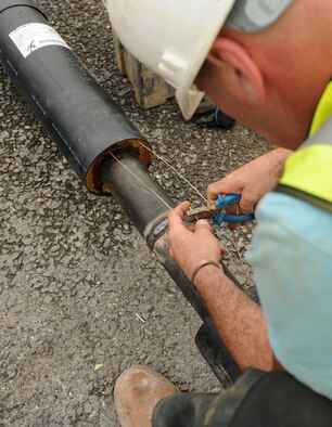 Allan Bates, a contractor from North Hampshire, England, crimps wires together Aug. 8, 2014, RAF Mildenhall, England. The wires help detect if the new heating system, being installed near the 100th Air Refueling Wing command post, has been contaminated by moisture. (U.S. Air Force photo/Airman 1st Class Jonathan Light/Released)