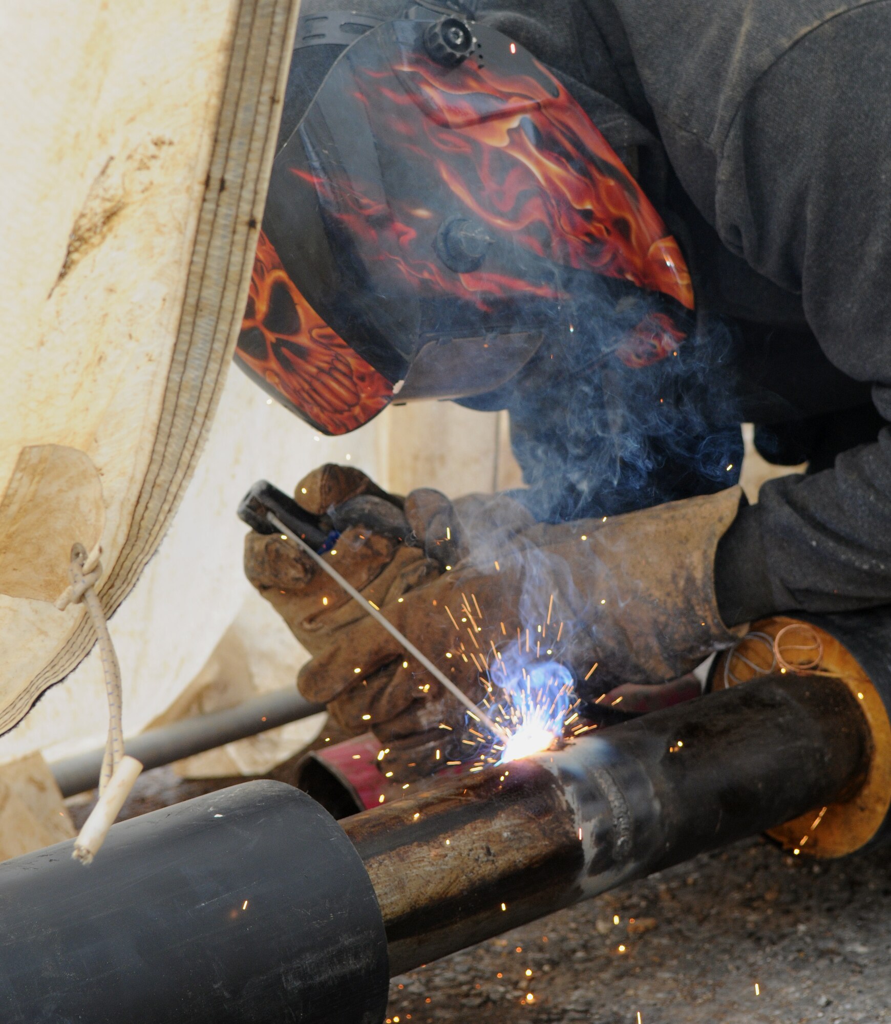 Duncan Steele, a contractor from North Hampshire, England, welds pipes together Aug. 8, 2014, on RAF Mildenhall, England. The pipes are a part of a new heating system being installed on base near the 100th Air Refueling Wing command post. (U.S. Air Force photo/Airman 1st Class Jonathan Light/Released)