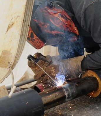 Duncan Steele, a contractor from North Hampshire, England, welds pipes together Aug. 8, 2014, on RAF Mildenhall, England. The pipes are a part of a new heating system being installed on base near the 100th Air Refueling Wing command post. (U.S. Air Force photo/Airman 1st Class Jonathan Light/Released)