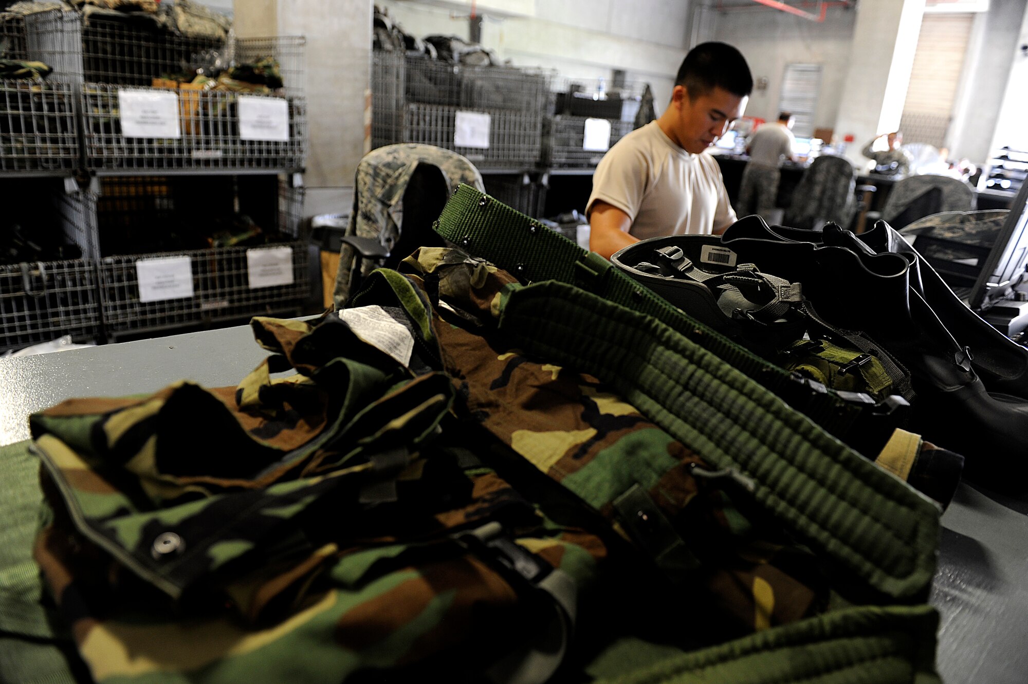 U.S. Air Force Airman 1st Class Joseph Tran, 18th Logistics Readiness Squadron individual protective equipment technician, prepares gear to be issued on Kadena Air Base, Japan, Aug. 13, 2014. Prior to mission focused exercises, Airmen are reminded to inspect and clean all components of their mission oriented protective posture gear. (U.S. Air Force photo by Senior Airman Maeson L. Elleman/Released)