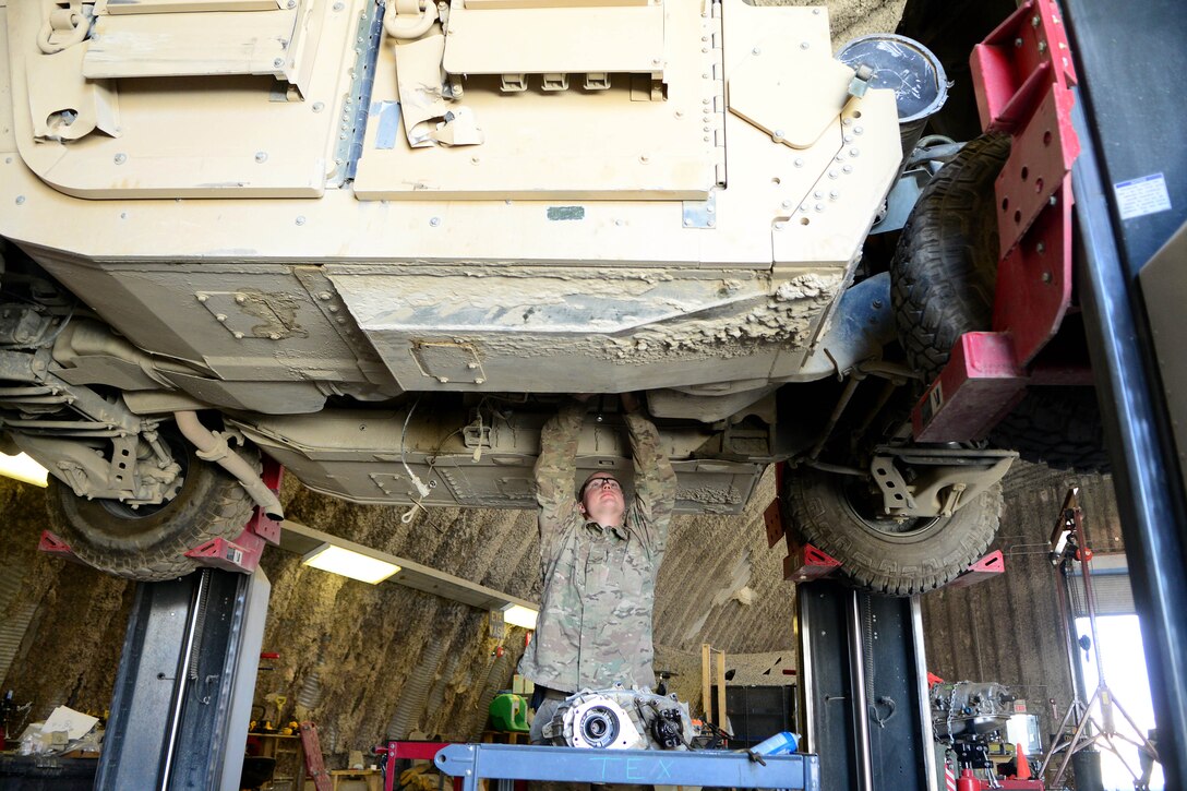 U.S. Air Force Senior Airman Christopher Horton, 455th Expeditionary Logistics Readiness Squadron vehicle maintenance equipment mechanic, inspects a HMMWV for transmission replacement at Bagram Airfield, Afghanistan Aug. 7, 2014. As part of vehicle maintenance, Horton is responsible for helping repair an average of 200 vehicles per month.  The shop maintains general and special purpose vehicles such as cars, tractors and forklifts.  Horton is deployed from the Tennessee Air National Guard and a native of Memphis, Tenn. (U.S. Air Force photo by Staff Sgt. Evelyn Chavez/Released)