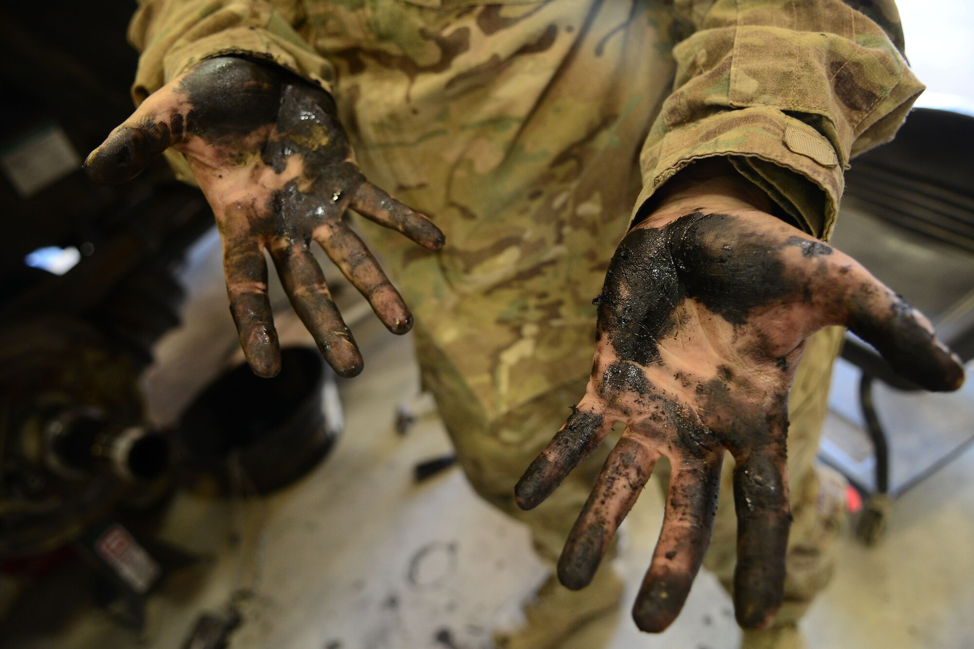 U.S. Air Force Senior Airman Saber Barrera, 455th Expeditionary Logistics Readiness Squadron fire truck and refueling mechanic shows off her greasy hands after repairing a fuel truck axel at Bagram Airfield, Afghanistan Aug. 7, 2014.  As a vehicle maintainer, Barrera helps ensure more than 20 refueling vehicles are operational and mission ready. Barrera is deployed from Nellis Air Force Base, Nev.  and a native of Anchorage, Alaska. (U.S. Air Force photo by Staff Sgt. Evelyn Chavez/Released)