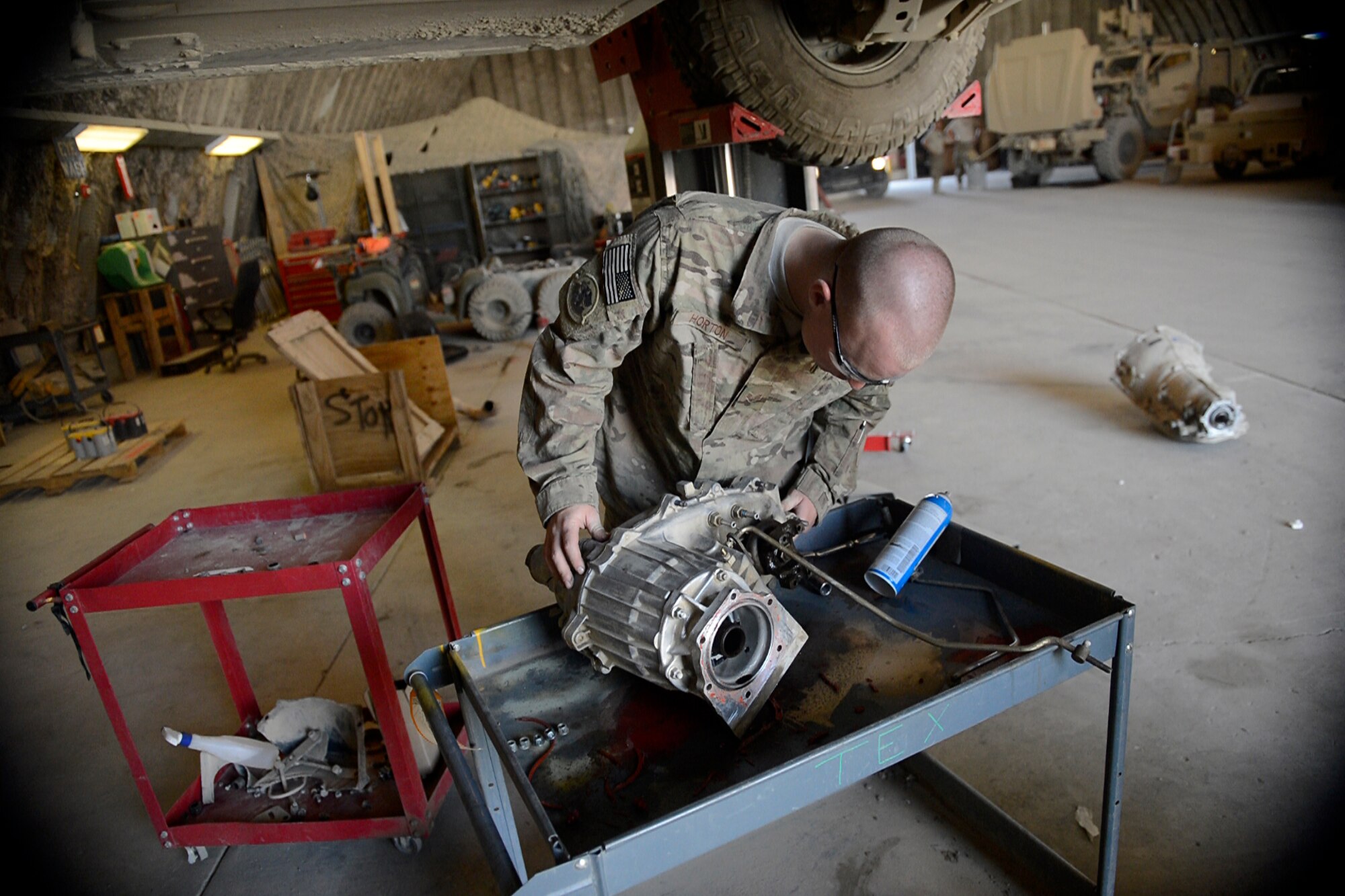 U.S. Air Force Senior Airman Christopher Horton, 455th Expeditionary Logistics Readiness Squadron vehicle maintenance equipment mechanic, inspects a HMMWV for transmission replacement at Bagram Airfield, Afghanistan Aug. 7, 2014.  As part of vehicle maintenance, Horton is responsible for repairing an average of 200 vehicles per month.  The shop maintains general and special purpose vehicles such as cars, tractors and forklifts.  Horton is deployed from the Tennessee Air National Guard and a native of Memphis, Tenn. (U.S. Air Force photo by Staff Sgt. Evelyn Chavez/Released)