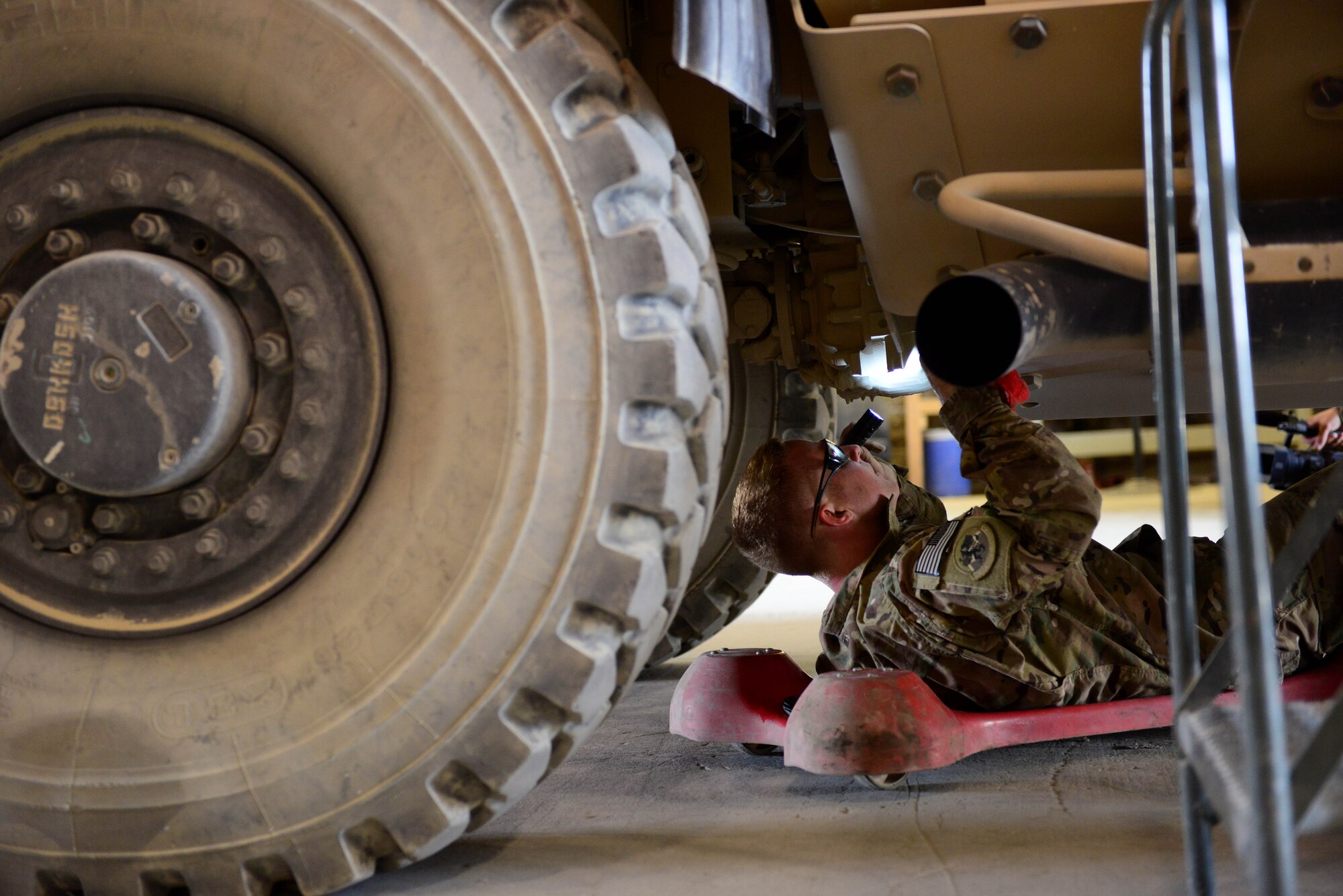 U.S. Air Force Senior Airman Michael Petrofsky, 455th Expeditionary Logistics Readiness Squadron vehicle maintenance equipment mechanic, repairs a Mine- Resistant Ambush Protection vehicle at Bagram Airfield, Afghanistan Aug. 2, 2014. Vehicle maintainers are responsible for maintaining and repairing mission essential vehicles.  The customer service section repairs an average of 200 vehicles per month.  Petrofsky is deployed from Holloman Air Force Base, N.M. and a native of Temecula, Calif.  (U.S. Air Force photo by Staff Sgt. Evelyn Chavez/Released)