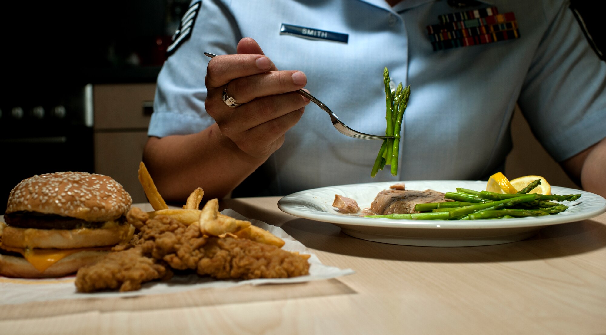 U.S. Air Force Staff Sgt. India Smith, 372nd Training Squadron Detachment 17 NCO in charge of knowledge operations from Ottawa, Kan., eats asparagus and fish during lunch Aug. 11, 2014, at Spangdahlem Air Base, Germany. Smith balances healthy eating is a tool to accomplish her goal of scoring in the excellent category for her physical fitness test. (U.S. Air Force photo by Senior Airman Rusty Frank/Released)