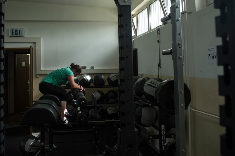 U.S. Air Force Staff Sgt. India Smith, 372nd Training Squadron Detachment 17 NCO in charge of knowledge operations from Ottawa, Kan., rests during a workout Aug. 11, 2014, at Spangdahlem Air Base, Germany. By performing combat fitness exercises, Smith is two dress sizes away from accomplishing one of her goals. (U.S. Air Force photo by Senior Airman Rusty Frank/Released)
