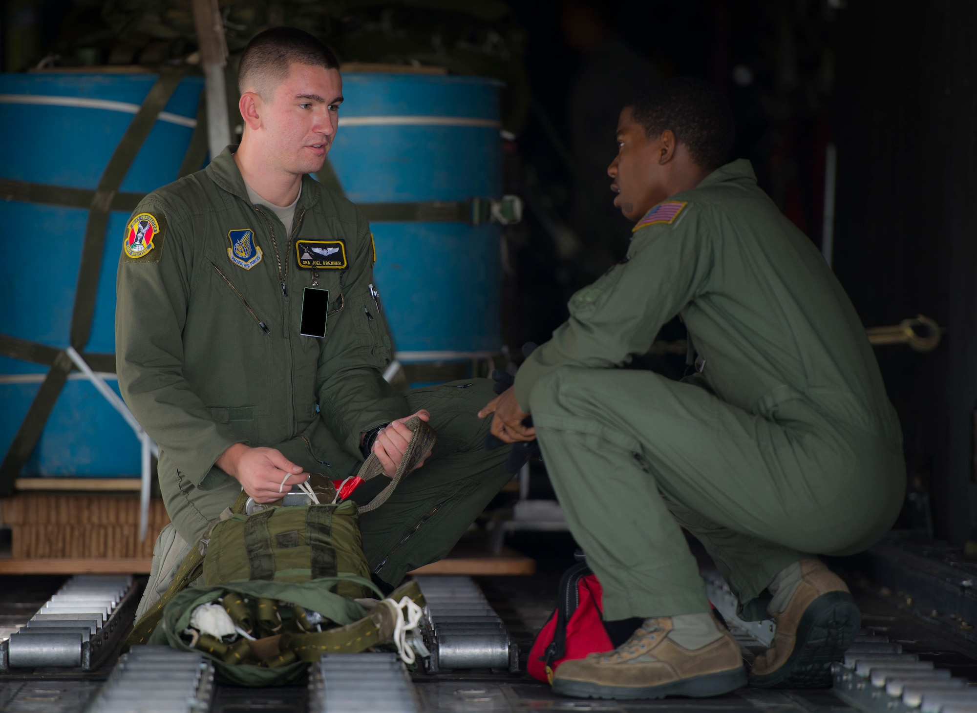 Senior Airman Joel Brenner, 36th Airlift Squadron loadmaster, discusses load procedures with a fellow loadmaster during Exercise RED FLAG-Alaska on Aug. 13, 2014, Joint Base Elmendorf-Richardson, Alaska. RED FLAG provides joint offensive counter-air, interdiction, close air support, and large force employment training in a simulated combat environment. (U.S. Air Force photo by Staff Sgt. Chad C. Strohmeyer/Released)