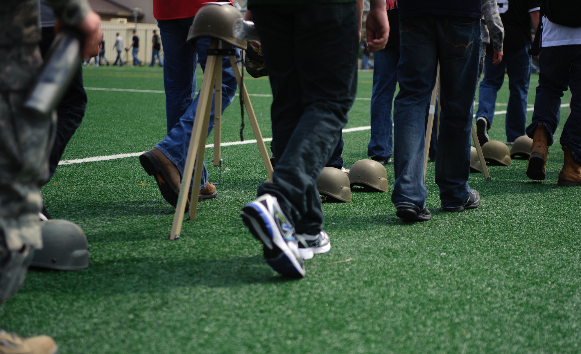 Ninety-nine helmets representing sexual assault cases dating back 10 years line the field as Airmen walk past them during the base-wide Sexual Assault Prevention and Response down day at Kunsan Air Base, Republic of Korea, May 22, 2014. In between each of the 99 were sets of three representing the statistically unreported cases believed to have occurred on base.(U.S. Air Force photo by Senior Airman Armando A. Schwier-Morales)