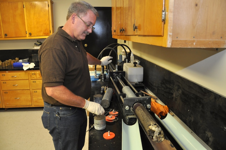Mike Wielputz, regional technical specialist, extrudes a soil sample from a drill tube and prepares it for testing at the U.S. Army Corps of Engineers Savannah District Environmental and Materials Unit. 