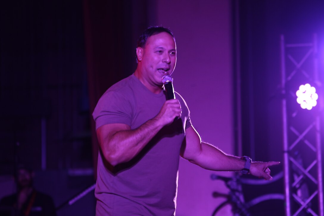 Mark Viera, comedian, points to the crowd and smiles while telling jokes during the Leatherneck Comedy Tour at the base theater Aug. 7, 2014. Viera was followed by a performance by the Purrfect Angelz.


