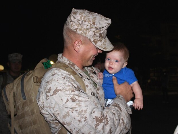 Cpl. Nickolas Collins meets his son, 6-month-old Karson Collins, for the first time Wednesday morning at Camp Pendleton, Calif. Collins returned early Wednesday from a seven-month deployment to Camp Leatherneck, Afghanistan, with Tango Battery, 5th Battalion, 11th Marine Regiment. Collins' wife, Annette Collins, made a sign saying, "I've waited my whole life to meet you" and dressed Karson in American flag-themed shorts and a shirt printed with "Awesome like daddy" for the occasion.