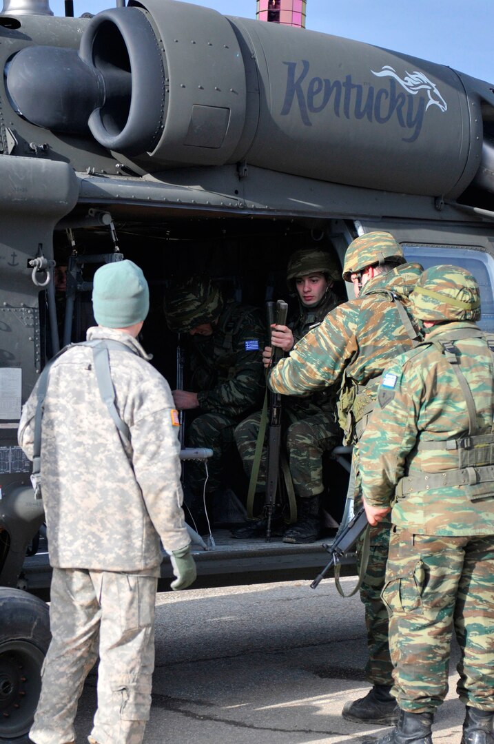 Greek Soldiers board a UH-60 Blackhawk helicopter from the Kentucky National Guard during hot/cold load training recently held at Camp Rigas Fereos near Camp Bondsteel, Kosovo.