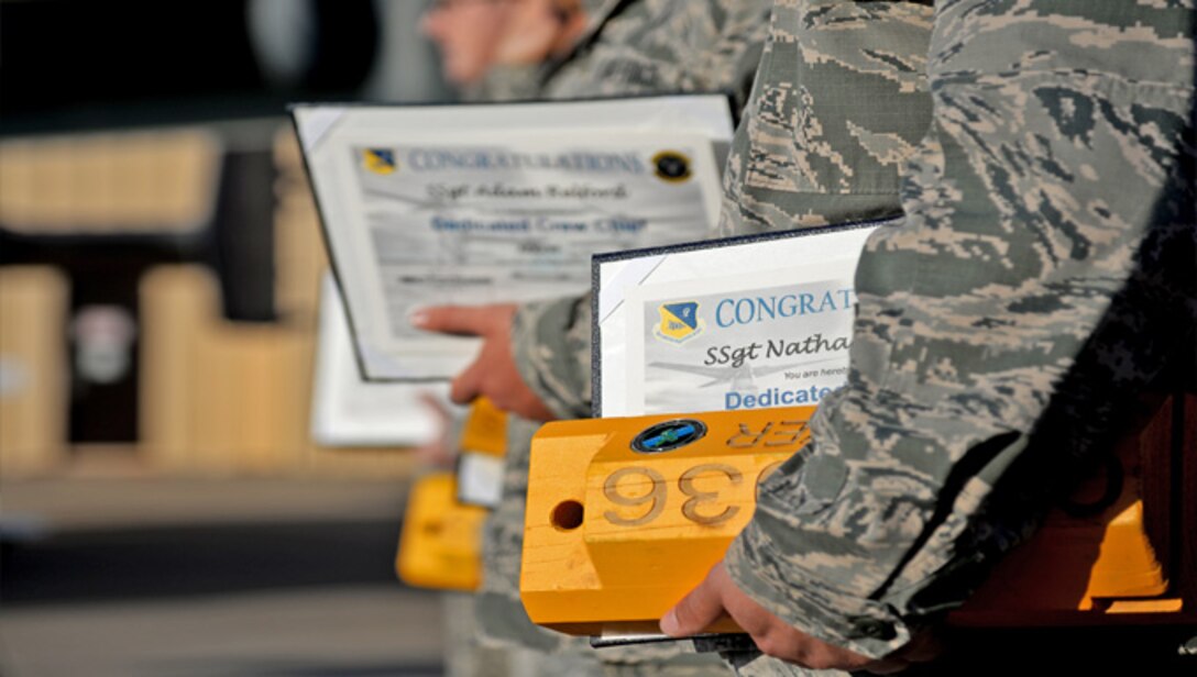 Members of the 3rd and 20th Aircraft Maintenance Units congratulate newly selected dedicated crew chiefs Aug. 4, 2014, by presenting them with a personalized set of chalks for their designated aircraft at Cannon Air Force Base, N.M. Being selected for this position is a demanding yet high honor, designated for those who have displayed exceptional initiative, management skills and leadership ability. (U.S. Air Force photo/Airman 1st Class Chip Slack)

