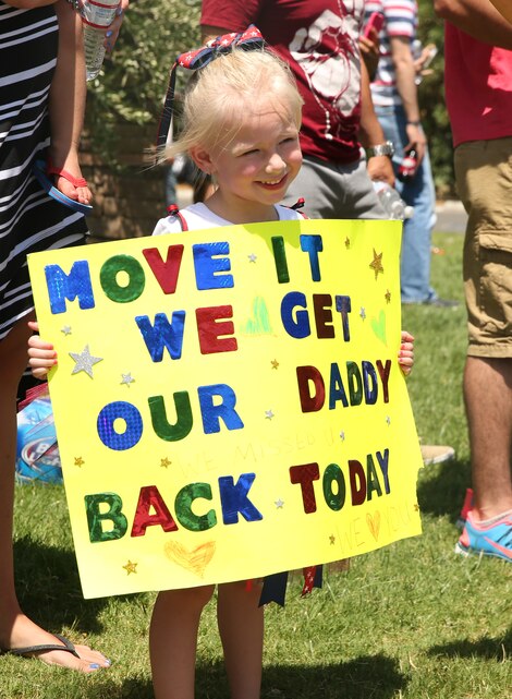 Autumn Burrell, 4, daughter of Staff Sgt. Nathan Burrell, operations chief, Combat Logistics Battalion 7, holds a sign up for her father to see during the CLB-7 homecoming at Desert Winds Golf Course, August 10, 2014. This homecoming was the last group of CLB-7 Marines returning from Afghanistan.