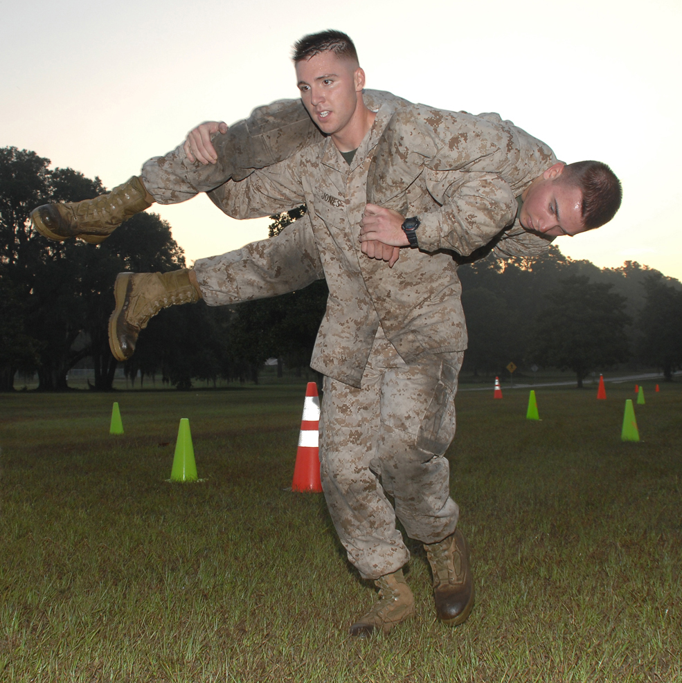 Cpl. Jacob Jones, distribution management specialist, Distribution Management Office, Marine Corps Logistics Base Albany, carries Cpl. Kyle Phelps, armorer, Logistics Support Division, MCLB Albany, during the maneuver-under-fire portion of the combat fitness test, Tuesday. 