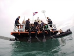 KOH RONG, Cambodia (Aug. 13, 2014) - Two members of the Cambodian Mine Action Center diver team prepare to enter the water during the final phase of open water training while 1st Sgt. David Chebahtah (left) and Staff Sgt. Bill Behr (right), both divers with the 7th Engineer Dive Detachment, supervise during a 36-day event, focused on building their in-water confidence as well as establishing their basic unit sustainment programs. 