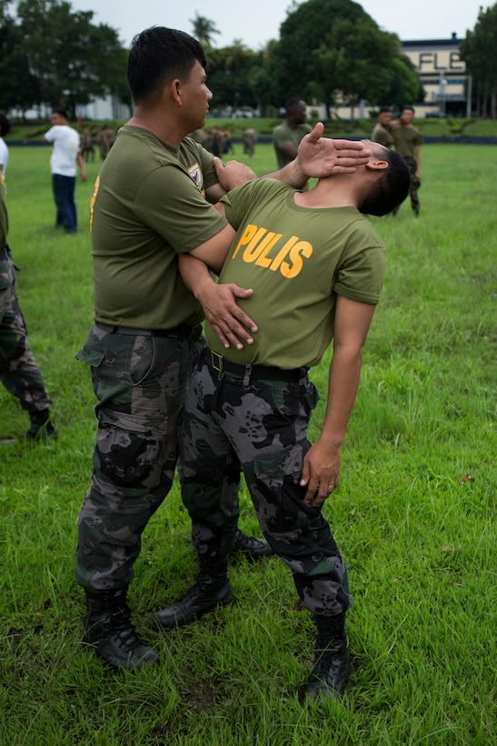 FORT BONIFACIO, Philippines – Police Officer Rafael B. Muchuelas, a lead instructor with the Philippine National Police (PNP), performs a Mechanical Advantage Control Hold (MACH) on Jonathan Catig, a police inspector with the PNP, Aug. 4, during Non-Lethal Weapons Executive Seminar 2014. NOLES is an annual field-training exercise and leadership seminar sponsored by U.S. Marine Corps Forces, Pacific, and hosted by various nations throughout the Asia-Pacific.  This is the 13th iteration of NOLES with members from the AFP, and Philippine National Police participating. 