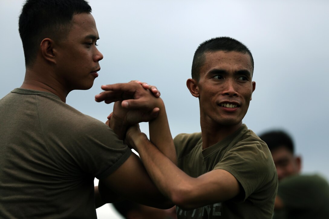 Philippine Air Force 2nd Lt. Wilzon Paul Nicolas (left) and 2nd Lt. Jayson Martir practice mechanical advantage control holds together at Fort Bonifacio, Philippines Aug. 04, 2014 during the Non-Lethal Weapons Executive Seminar field training exercise. The effective use of non-lethal weapons can be extremely valuable during rescue missions, for force protection in civil disturbances, while controlling rioting and prisoners of war, for checkpoint or convoy operations, HA/DR operations, or in situations in which civilians are used to mask a military attack. 