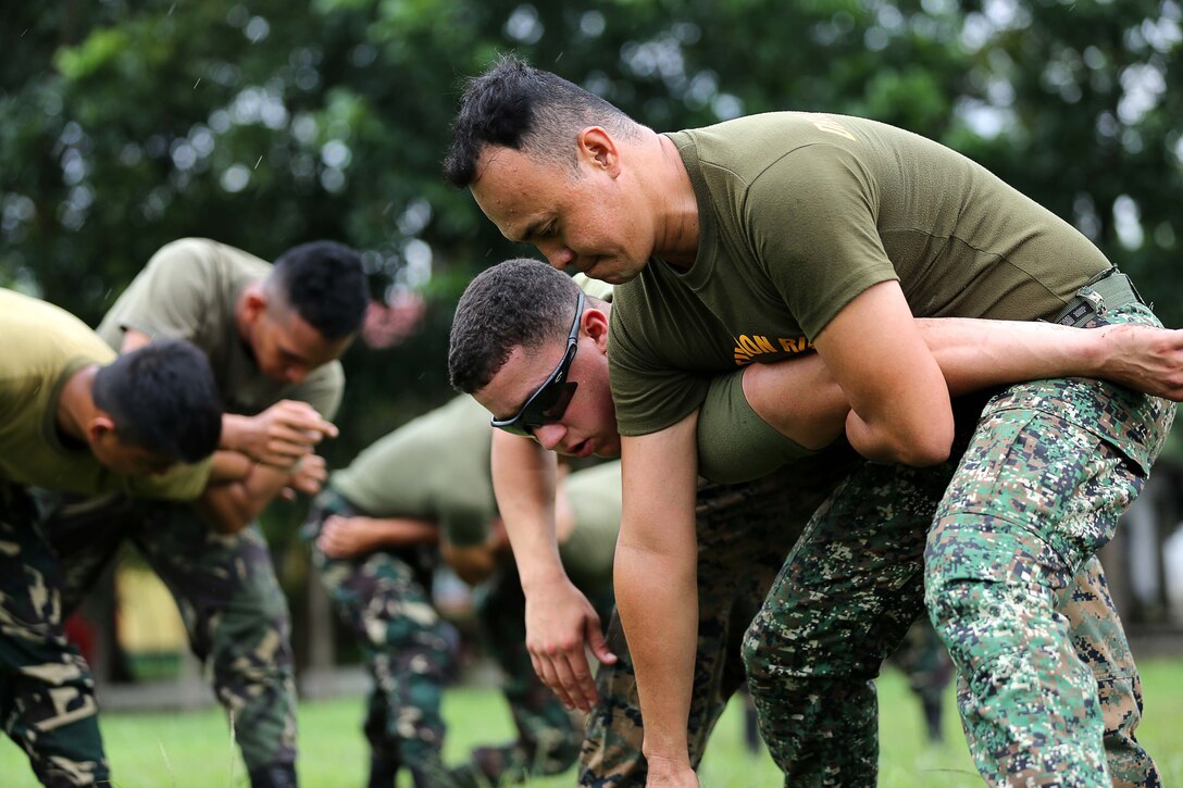 Philippine Marine Corps Staff Sgt. Eric Castino performs mechanical advantage control holds on U.S. Marine Corps Lance Cpl. Joshua Rodriguez, with 3rd Law Enforcement Battalion, III Marine Headquarters Group, at Fort Bonifacio, Philippines Aug. 04, 2014 during the Non-Lethal Weapons Executive Seminar field training exercise. The effective use of non-lethal weapons can be extremely valuable during rescue missions, for force protection in civil disturbances, while controlling rioting and prisoners of war, for checkpoint or convoy operations, HA/DR operations, or in situations in which civilians are used to mask a military attack. 