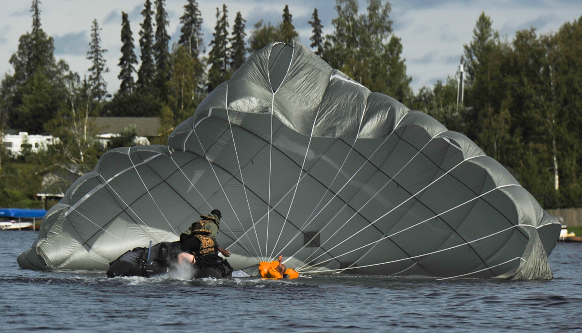 Paratroopers assigned to the 4th Infantry Brigade Combat Team (Airborne), 25th Infantry Division, U.S. Army Alaska, pick up a soldier after a water jump into Big Lake, Alaska, Wednesday, Aug. 6, 2014, with T-11 parachutes. This training event prepares the brigade's troopers for potential water landings, and highlights the unit's ability to perform airborne operations under challenging conditions and locations anywhere in the world. (U.S. Air Force photo/Justin Connaher)