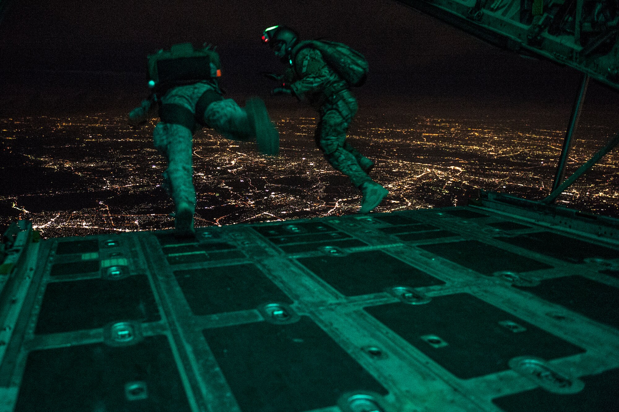 U.S. Air Force Staff Sgt. Ben Johnas, 374th Operation Support Squadron survival, evasion, resistance and escape instructor, performs a high altitude-low opening jump with the 31st Marine Expeditionary Unit jump masters out of a C-130H Hercules aircraft from the 36th Airlift Squadron, Yokota Air Base, Japan, Aug. 11, 2014. The 36th AS conducts theater airlift, special operations, aeromedical evacuation, search and rescue, repatriation and humanitarian relief missions with a C-130H Hercules mission-ready aircrew while being the only forward-based tactical airlift squadron in the Pacific. (U.S. Air Force photo by Staff Sgt. Stephany Richards/ Released)