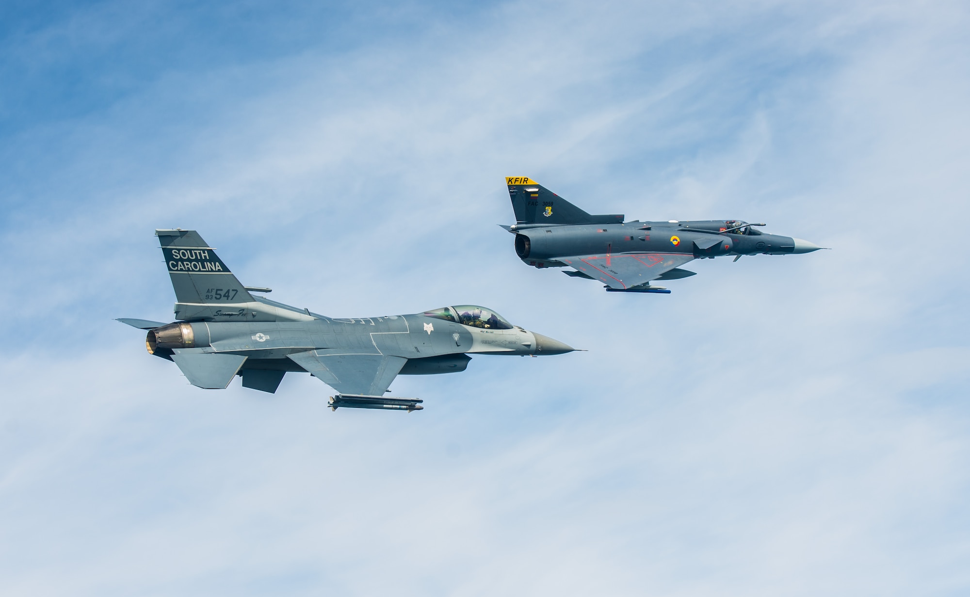 A South Carolina Air National Guard F-16 flies alongside a Colombian air force Kfir during a training flight Aug. 12 over Colombia. Nearly 100 Airmen and six F-16s from the 169th Fighter Wing at McEntire Air National Guard Base are participating in the combined air operation engagement, which is the first major joint-air engagement opportunity under the auspices of the South Carolina's State Partnership Program with Colombia. (U.S. Air Force photo by Maj. Matt Booth/Released)