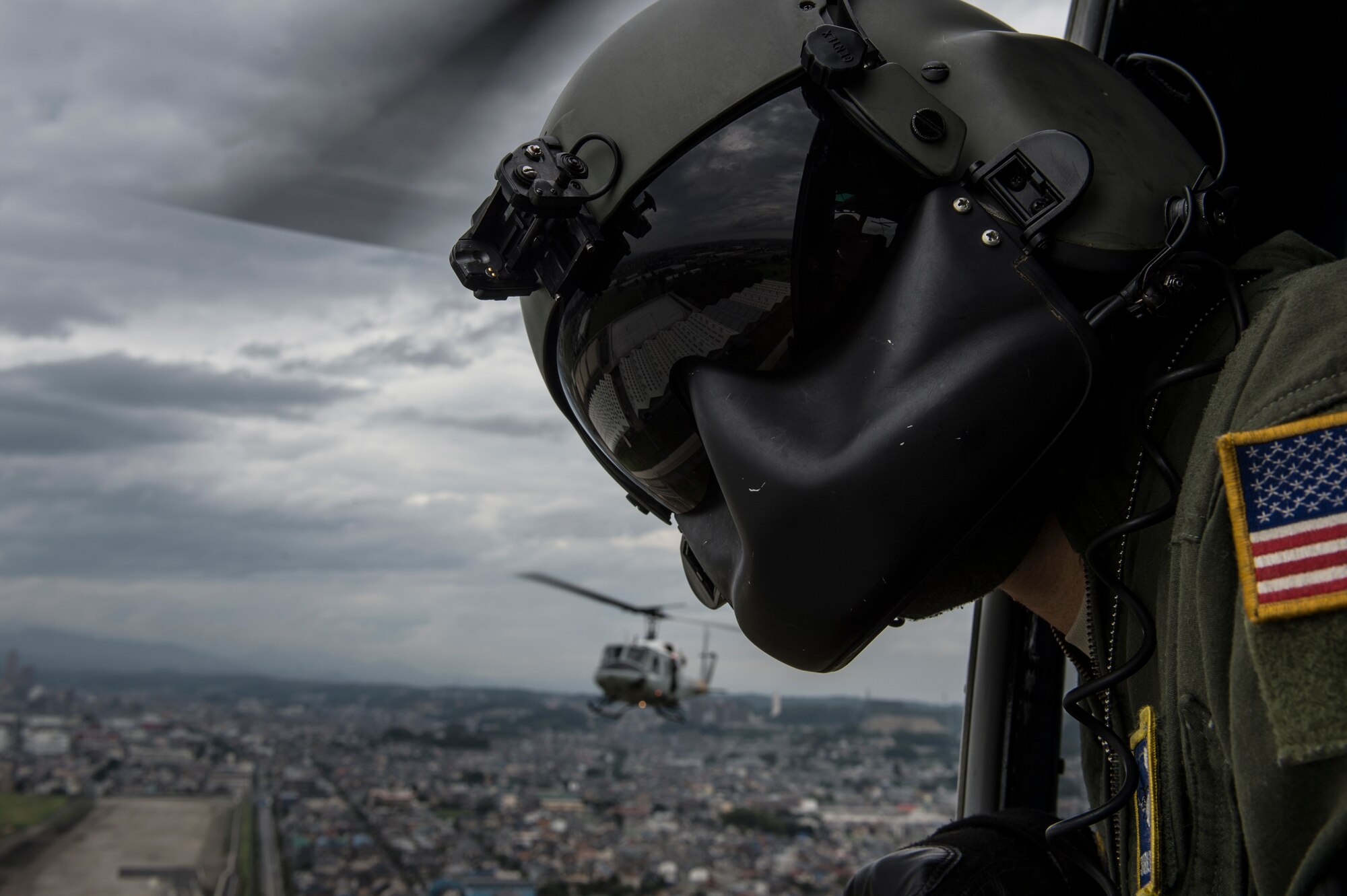 U.S. Air Force Staff Sgt. Michael Wright, 459th Airlift Squadron UH-1N Huey crew chief, watches for obstacles during take-off for a training mission in Tokyo, Japan, outside of Yokota Air Base, Aug. 12, 2014. The 459th AS maintains both UH-1N and C-12J mission-ready aircrews to conduct aeromedical evacuation, search and rescue and priority airlift missions throughout the Pacific.  (U.S. Air Force photo by Staff Sgt. Stephany Richards/ Released)