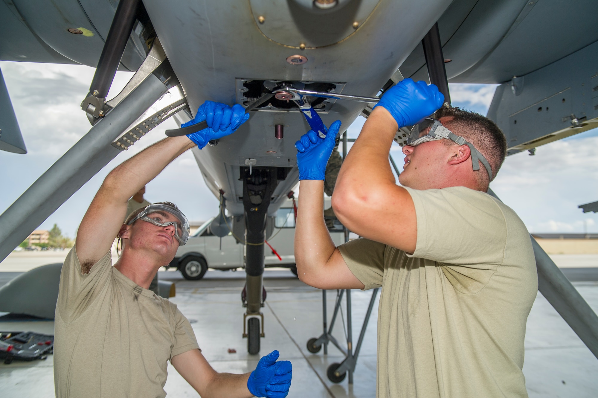 Airman 1st Class Jordan Pool and Airman 1st Class Daniel Hawley, 49th Aircraft Maintenance Squadron MQ-9 Reaper crew chiefs, perform a routine inspection on an MQ-9 remotely piloted aircraft at Holloman Air Force Base, N.M., Aug. 12. The 49th AMXS thoroughly inspects each part of the aircraft before takeoff and after landing, looking for any discrepancies that could interfere with the proper operation of the aircraft. Inspections are performed based on various factors including total hours flown and discrepancies noticed or reported during training sorties. Additional inspections are completed on several milestones including 200, 400, 800 and 2,000 hours of flight time. Each inspection is more in-depth as the flight hours increase.  (U.S. Air Force photo by Airman 1st Class Aaron Montoya / Released)