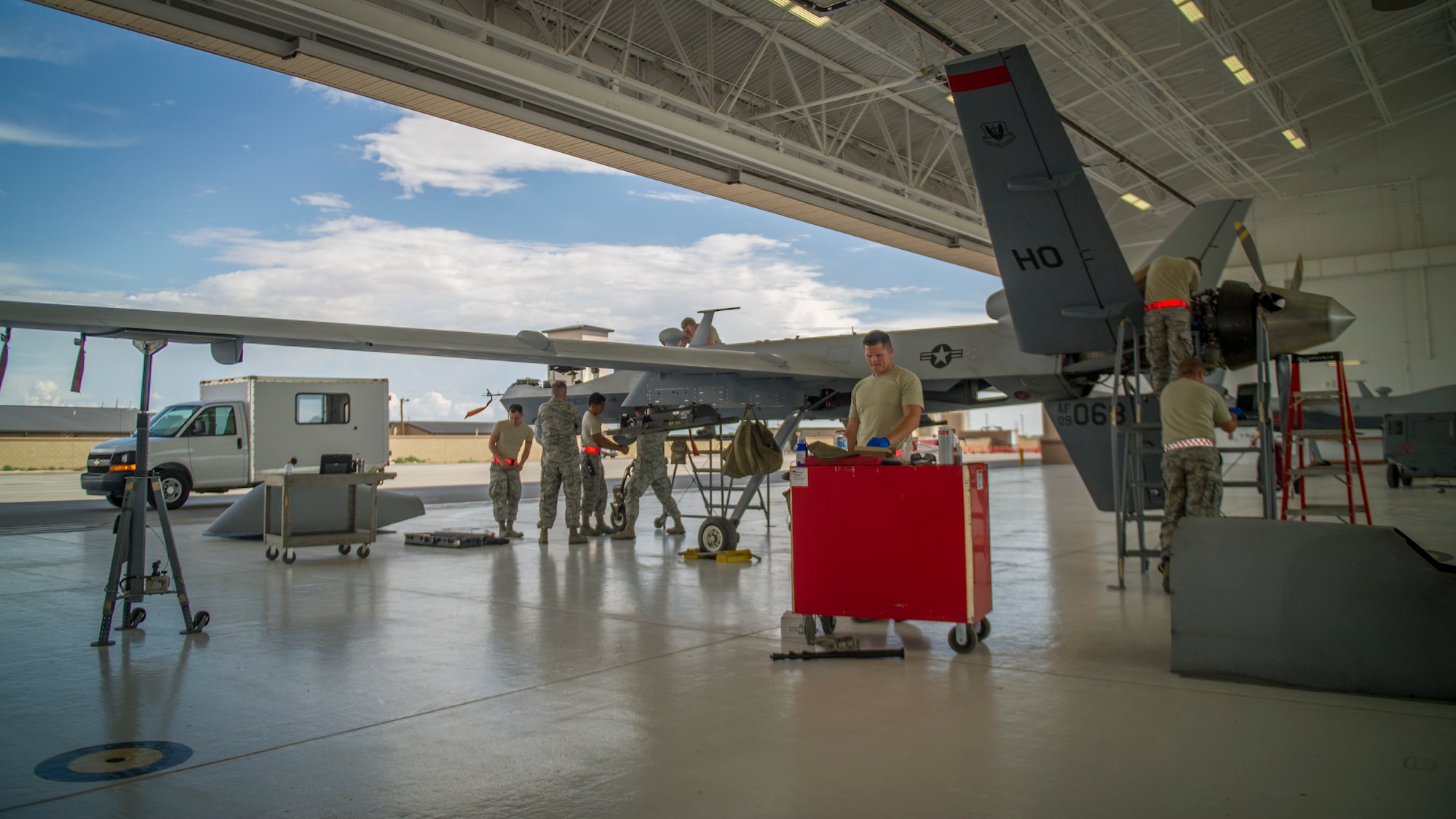 MQ-9 Reaper crew chiefs from the 49th Aircraft Maintenance Squadron perform a routine inspection on an MQ-9 remotely piloted aircraft at Holloman Air Force Base, N.M., Aug. 12. The 49th AMXS thoroughly inspects each part of the aircraft before takeoff and after landing, looking for any discrepancies that could interfere with the proper operation of the aircraft. Inspections are performed based on various factors including total hours flown and discrepancies noticed or reported during training sorties. Additional inspections are completed on several milestones including 200, 400, 800 and 2,000 hours of flight time. Each inspection is more in-depth as the flight hours increase.  (U.S. Air Force photo by Airman 1st Class Aaron Montoya / Released)
