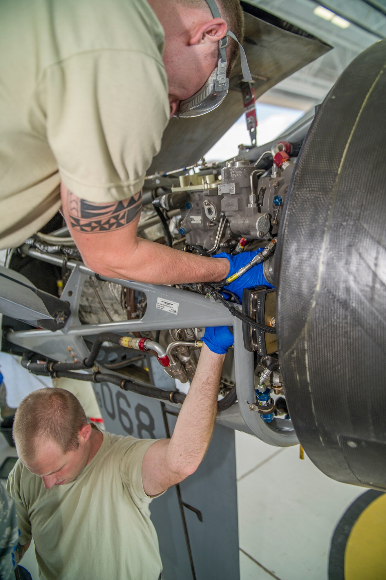 Airman 1st Class Chase Russell and Staff Sgt. Richard Cole, 49th Aircraft Maintenance Squadron MQ-9 Reaper crew chiefs, perform maintenance on an MQ-9 remotely piloted aircraft during a 400-hour engine inspection at Holloman Air Force Base, N.M., Aug. 12. The 49th AMXS thoroughly inspects each part of the aircraft before takeoff and after landing, looking for any discrepancies that could interfere with the proper operation of the aircraft. Inspections are performed based on various factors including total hours flown and discrepancies noticed or reported during training sorties. Additional inspections are completed on several milestones including 200, 400, 800 and 2,000 hours of flight time. Each inspection is more in-depth as the flight hours increase.  (U.S. Air Force photo by Airman 1st Class Aaron Montoya / Released)