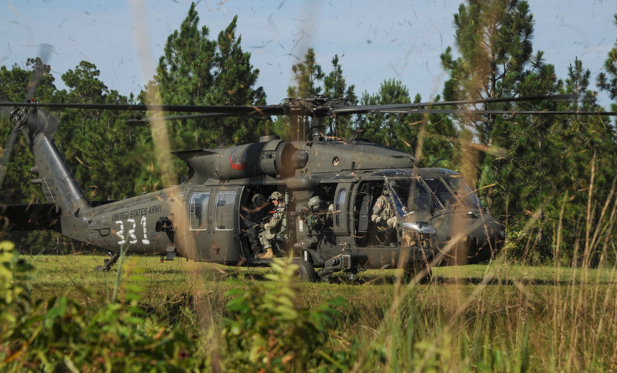 An Army UH-60 Black Hawk lands with a group of Soldiers to prepare for an extraction of Airmen as part of a joint training exercise July 30, 2014 at Ft. Polk, La. Soldiers and Airmen often work together when training for contingency operations.  (U.S. Air Force photo by Airman 1st Class Harry Brexel)