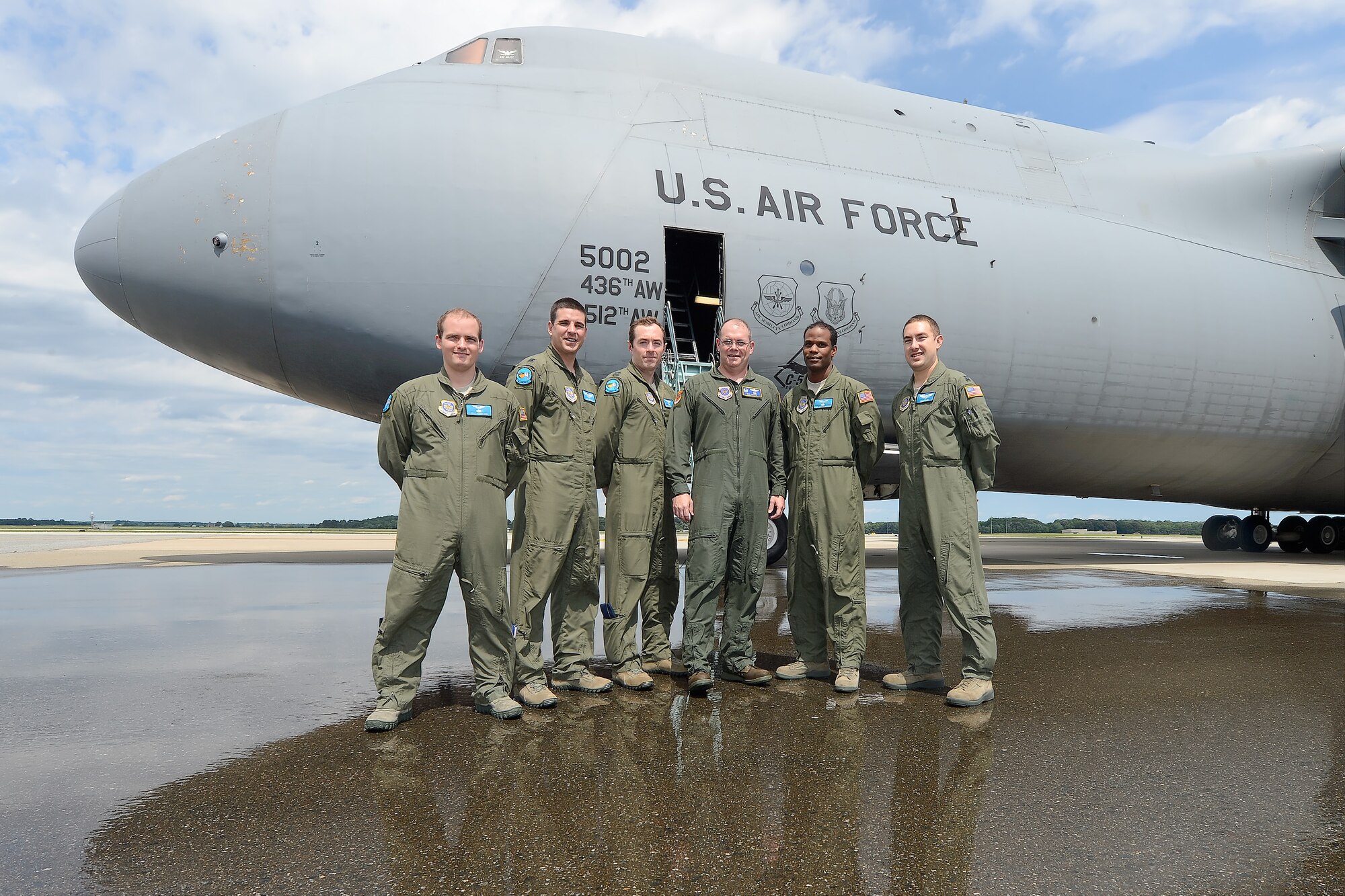 Col. Richard G. Moore, Jr., 436th Airlift Wing commander, (center) poses with the crew of C-5M Super Galaxy, 85-0002, following his final flight as the leader of Team Dover on Aug. 14, 2014, at Dover Air Force Base, Del. From left to right are: Staff Sgt. Robin Ogg, Capt. Joshua Moores, Capt. Michael Zeleski, Col. Richard G. Moore, Jr., Tech. Sgt. Adrian Jackson, Capt. Chad Rubin. Moore received the traditional hose-down following the final flight at Dover AFB. (U.S. Air Force photo/Greg L. Davis) 