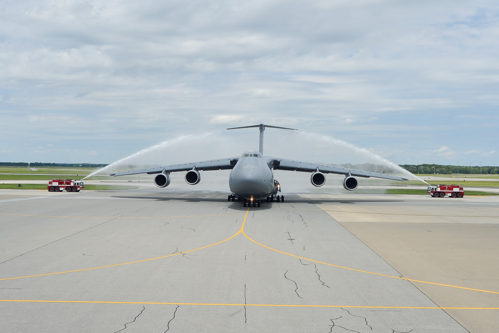 Col. Richard G. Moore, Jr., 436th Airlift Wing commander, taxis C-5M Super Galaxy, 85-0002, through arches of water made by firetrucks of the 436th Civil Engineer Squadron Fire Department, after completing his final flight as the leader of Team Dover Aug. 14, 2014, at Dover Air Force Base, Del. Moore's flight included a full-mission profile to include air-refueling, route navigation and pilot proficiency items. (U.S. Air Force photo/Greg L. Davis)