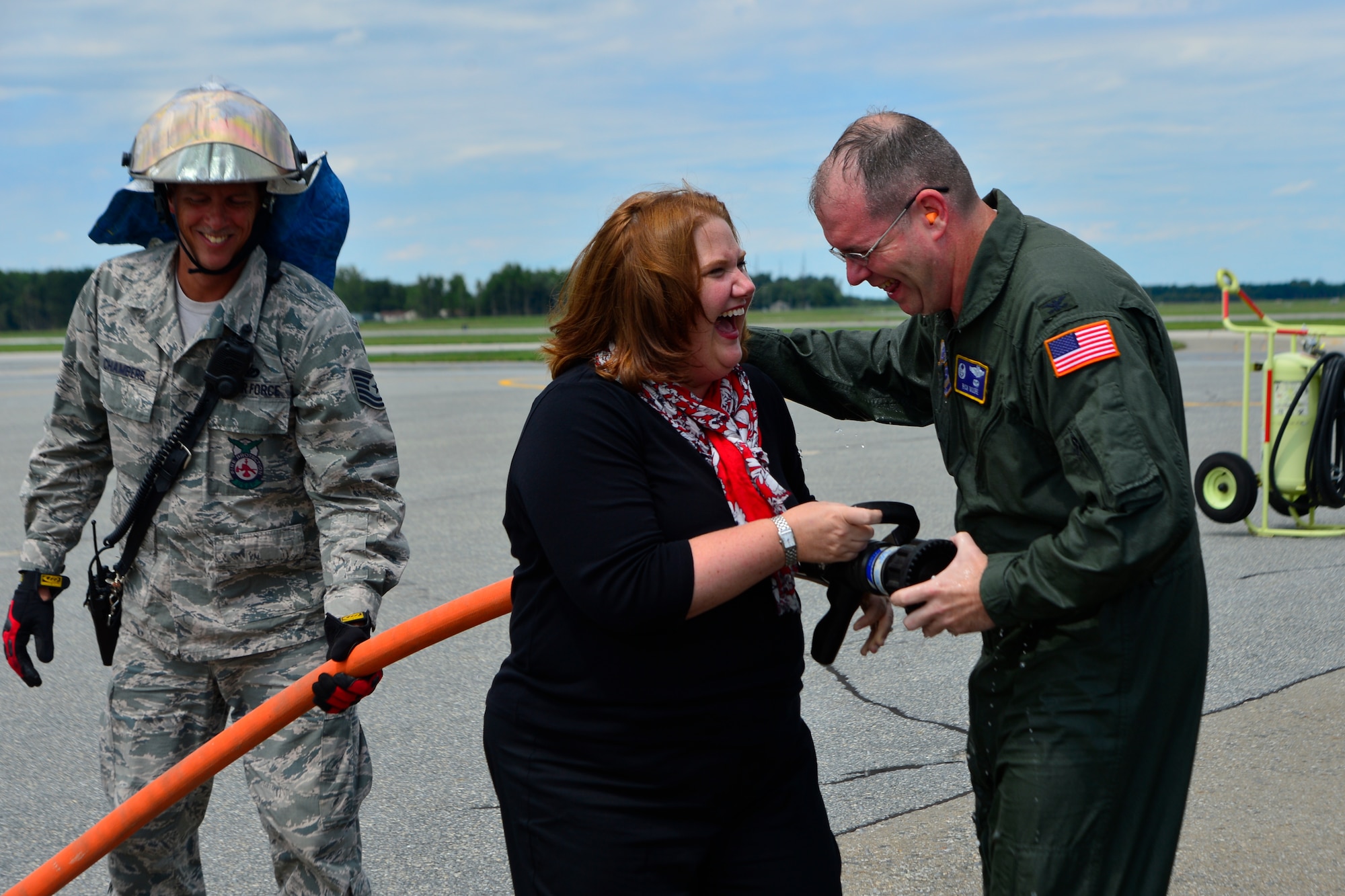 Col. Richard G. Moore, Jr., 436th Airlift Wing commander, laughs with his wife, Kristin, after his Fini Flight Aug. 14, 2014, at Dover Air Force Base Del. Kristin greeted her husband by spraying a firehouse at him after his flight. (U.S. Air Force photo/Airman 1st Class William Johnson)