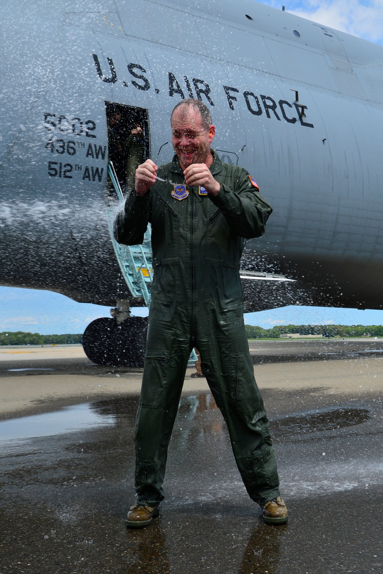 Col. Richard G. Moore, Jr., 436th Airlift Wing commander, is sprayed with water after conducting his Fini Flight Aug. 14, 2014, at Dover Air Force Base Del. Moore was sprayed down by family members and squadron commanders after the flight. (U.S. Air Force photo/Airman 1st Class William Johnson)