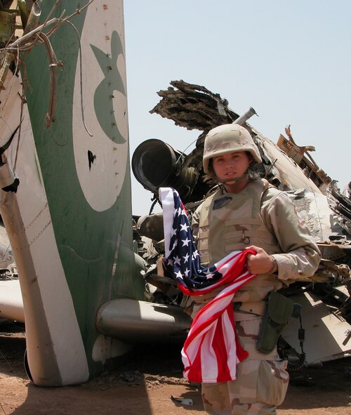 Former U.S. Air Force 2nd Lt. Rebecca Dickey, public affairs officer, stands by a destroyed aircraft after a massive assault at Baghdad International Airport, Iraq, in 2002. Dickey spent four years in the military and deployed to Baghdad in support of Operation Iraqi Freedom. While deployed she was able to document airstrike damage and effectiveness. (Courtesy photo)