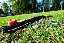A 12-guage shotgun, sporting clay targets and ammunition lie on the ground before Rebecca Dickey, wife of U.S. Air Force Maj. Jeremy Dickey, 71st Rescue Squadron HC-130P Combat King pilot, continues her training session at a shooting range in Quitman, Ga., July 29, 2014. Dickey trains weekly for the national shooting competition, Remington Great Americans Shoot, Sept. 20, in Liberty, Texas. Her team, “Lady Laura and the Smoking Hot BB’s,” will compete against 19 other teams to win money for specific military charities. (U.S. Air Force photo by Senior Airman Olivia Bumpers/Released)
