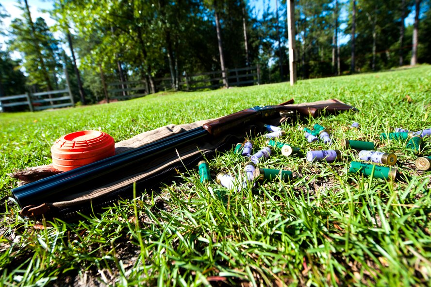 A 12-guage shotgun, sporting clay targets and ammunition lie on the ground before Rebecca Dickey, wife of U.S. Air Force Maj. Jeremy Dickey, 71st Rescue Squadron HC-130P Combat King pilot, continues her training session at a shooting range in Quitman, Ga., July 29, 2014. Dickey trains weekly for the national shooting competition, Remington Great Americans Shoot, Sept. 20, in Liberty, Texas. Her team, “Lady Laura and the Smoking Hot BB’s,” will compete against 19 other teams to win money for specific military charities. (U.S. Air Force photo by Senior Airman Olivia Bumpers/Released)