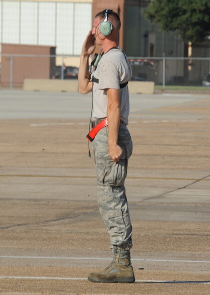Senior Airman Mitchell Dexter, 2nd Aircraft Maintenance Squadron crew chief, renders a salute to a B-52H Stratofortress aircrew preparing to launch during a Minimum Interval Takeoff on Barksdale Air Force Base, La., Aug. 14, 2014. The small launch window of a MITO, combined with turbulence created by preceeding aircraft that can create rough air for the following aircraft, gives aircrew an opportunity to demonstrate their skills and abilities. (U.S. Air Force photo/Staff Sgt. Sean Martin)