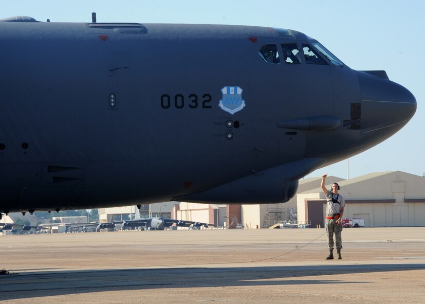 Senior Airman Mitchell Dexter, 2nd Aircraft Maintenance Squadron crew chief, communicates with aircrew in the cockpit of a B-52H Stratofortress during a Minimum Interval Takeoff on Barksdale Air Force Base, La., Aug. 14, 2014. A MITO is executed to allow the B-52 to quickly respond and deliver precision munitions at a moment's notice. Starter cartridges, filled with gun powder, are used during this takeoff instead of the standard, compressed-air takeoff.  (U.S. Air Force photo/Staff Sgt. Sean Martin)



