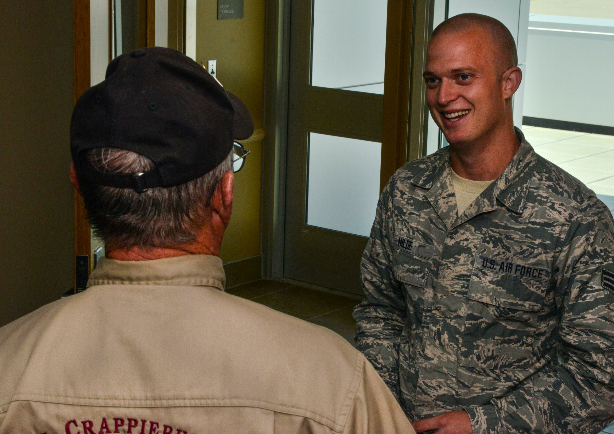 Retired Senior Master Sgt. Dennis Miller discusses weather forecast equipment with Senior Airman Scott Hilde, 5th Operations Squadron weather forecaster, on Minot Air Force Base, N.D., Aug. 8, 2014. During his career, Miller worked at Air Force Communications Command, Scott AFB, Illinois, where he field tested new forecasting technology, and managed the world-wide solar maintenance program. (U.S. Air Force photo/Senior Airman Stephanie Morris.)